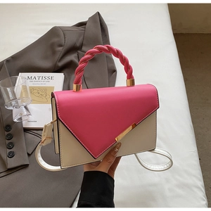 Detail view of pink and white handbag featuring a V-shaped flap and woven handle