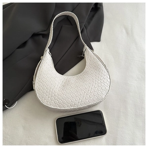 Detail of white woven crescent hobo bag with silver metal buckle and zipper closure