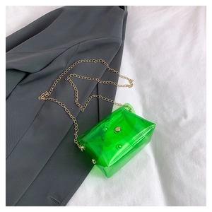 Dettaglio mini borsa in PVC trasparente verde neon con catena dorata e fibbia metallica