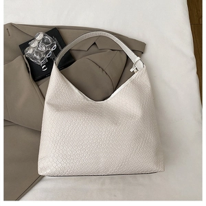 Detail shot of white woven texture on minimalist hobo bag with smooth wide strap