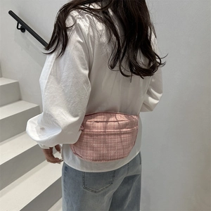 Sac de poitrine à carreaux roses avec bandoulière réglable porté par un mannequin sur escalier
