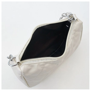 Top view of cream quilted bag showing zipper closure and spacious black fabric interior