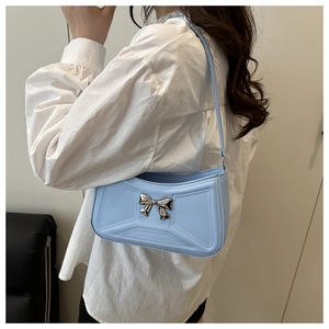 Vue latérale du sac bleu clair avec nœud argenté et coutures géométriques chics
