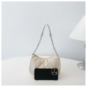 Detail of cream quilted shoulder bag with silver chain strap and phone for scale