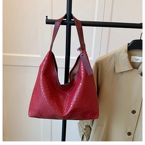 Detail of red woven texture on a large hobo shoulder bag with fashion leather tag