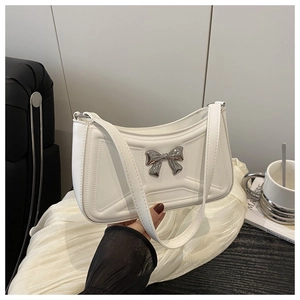 Détail du sac blanc avec nœud en métal argenté et texture matelassée en café chic