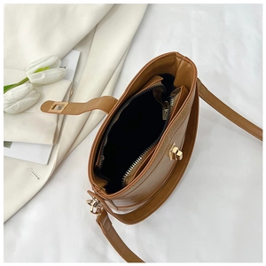 Detailed interior of brown leather bucket bag with gold twist lock and zipper closure
