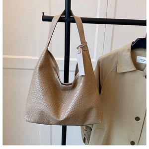 Detailed view of khaki woven texture and large capacity hobo bag on a display rack