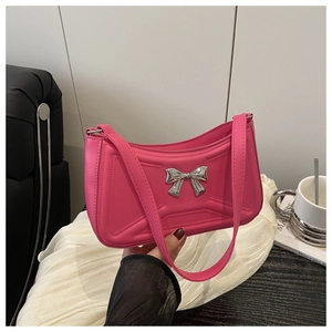 Gros plan du sac porté épaule rose avec surpiqûres géométriques et nœud argenté