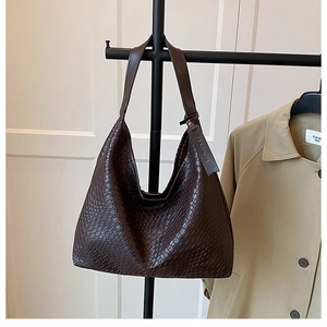 Close-up of deep brown woven leather hobo tote bag featuring a decorative fashion tag