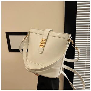 Detail showing white bucket bag with a golden turn-lock closure and dual shoulder straps