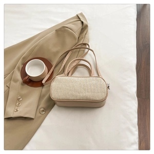Flat lay of a woven brown leather handbag styled with a blazer and coffee cup
