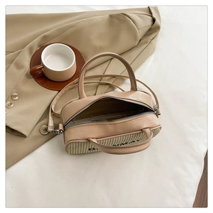 Top-down view of beige woven handbag with dual handles and detachable shoulder strap