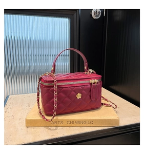 Detail of burgundy quilted leather bag with gold floral hardware and chain strap