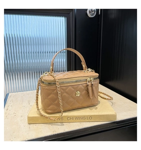 Close-up of khaki quilted leather crossbody bag with chain strap and flower metal hardware