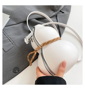 Detail of white gourd-shaped bag featuring woven rope trim and metal zipper closure