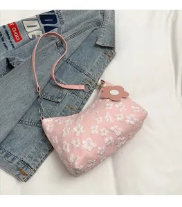 Detailed view of pink floral shoulder bag with 3D flower texture and matching charm