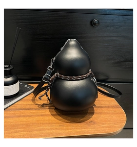Macro shot of unique gourd-shaped black leather bag with decorative textured rope