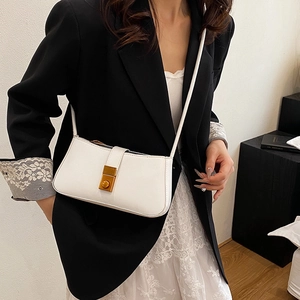 Chic beige crossbody square bag with gold buckle shown on a model in minimalist style