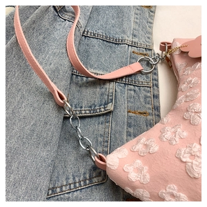 Detail of pink canvas bag with white 3D floral appliques and silver chain strap
