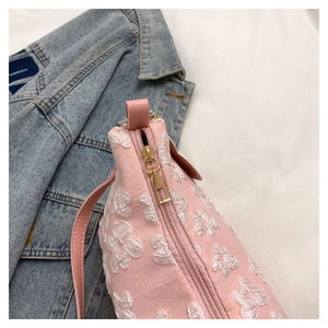 Detailed view of pink floral textured fabric and high-quality gold metal zipper puller
