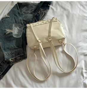 Detailansicht des cremeweißen Stepprucksacks mit Kunstledertextur und goldenen Metallbeschlägen