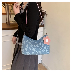 Detail of light blue floral underarm bag with pink strap and 3D flower embroidery