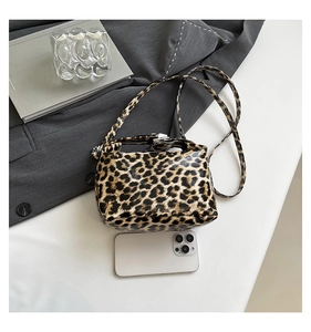 Leopard print crossbody bag shown with a smartphone for size reference in a stylish setting