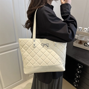 White quilted tote bag with silver bow accent and large capacity for daily commute