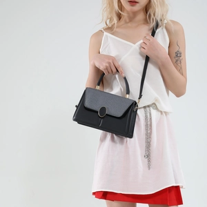 Elegant black and grey paneled crossbody handbag with a circular gold clasp for women