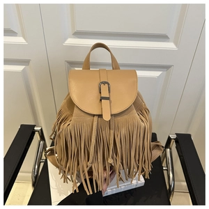 Detail view of khaki faux suede backpack with bohemian tassels and metal buckle closure