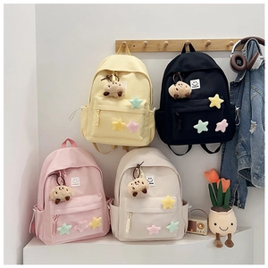 Detail view of four colorful nylon backpacks with star decor and cute sheep keychains