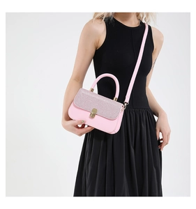 Détail du sac à bandoulière rose avec strass argentés et fermoir rotatif doré élégant