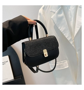 Détail du sac bandoulière noir avec paillettes argentées et fermoir rotatif doré