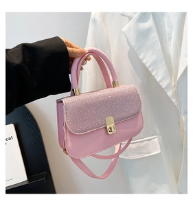 Détail du petit sac rose à bandoulière avec rabat pailleté et boucle métallique dorée