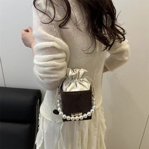 Brown leather box bag with pearl handle, drawstring closure and gold chain strap