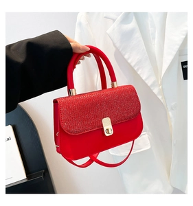 Détail du sac à main rouge à paillettes avec fermoir rotatif rectangulaire doré