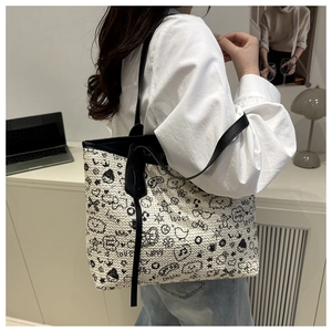 Woven tote bag featuring black and white textures with stylish cartoon graffiti details