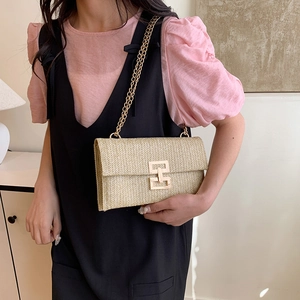 Pochette enveloppe beige tissée avec chaîne dorée pour un porté épaule décontracté