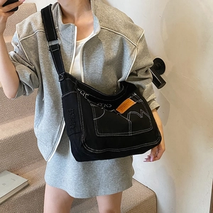 Sac à bandoulière tendance en toile denim avec surpiqûres blanches et étiquette sport