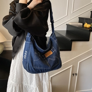 Sac à épaule en jean bleu foncé avec coutures blanches et détails vintage délavés