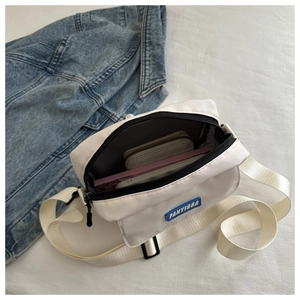 Internal view of white crossbody bag showing storage for phone and long wallet
