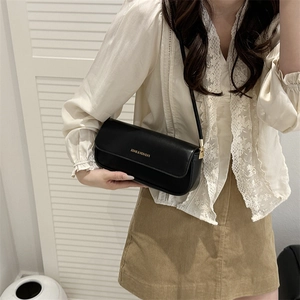 Minimalist black patent leather shoulder bag with fine strap and text detail