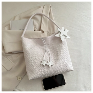 Detail of white woven texture tote bag with star charms and drawstring closure