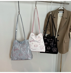 Detail view of silver, white, and black tote bags with cute cartoon cat graffiti prints