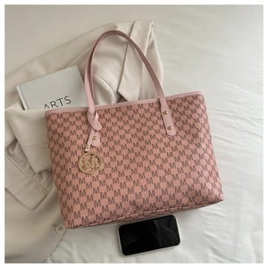 Détail du cabas rose à motif M sur blazer beige avec livres et téléphone portable