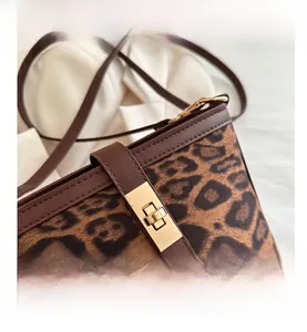 Détail du sac à bandoulière léopard avec cuir marron et fermoir métallique doré brillant