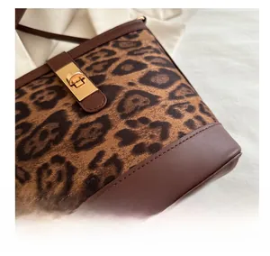 Détail du sac à main léopard montrant la texture fausse fourrure et le fermoir doré