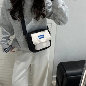 Piccola borsa a tracolla minimalista bicolore nero e bianco con tracolla larga regolabile