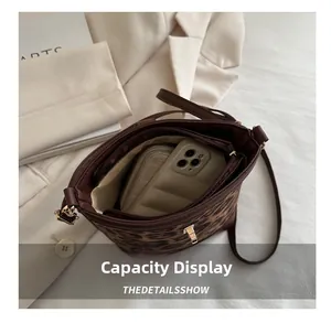 Vue intérieure du sac seau léopard montrant la capacité pour téléphone et portefeuille